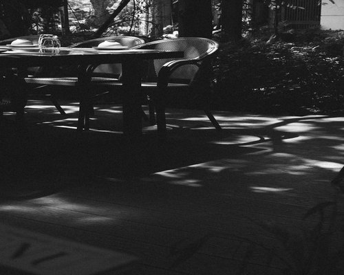 A morning coffee mug on a table reflecting gentle ambient lighting near a patio