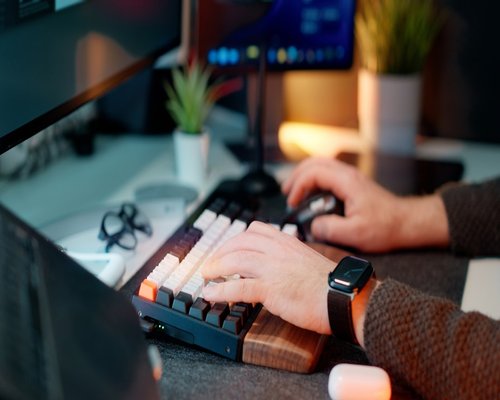 A person typing on a neat mechanical keyboard during a scheduled break interval in a modern workspace