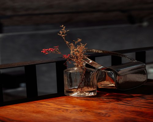 A smartphone resting face down on a wooden coffee table next to a water bottle during family time